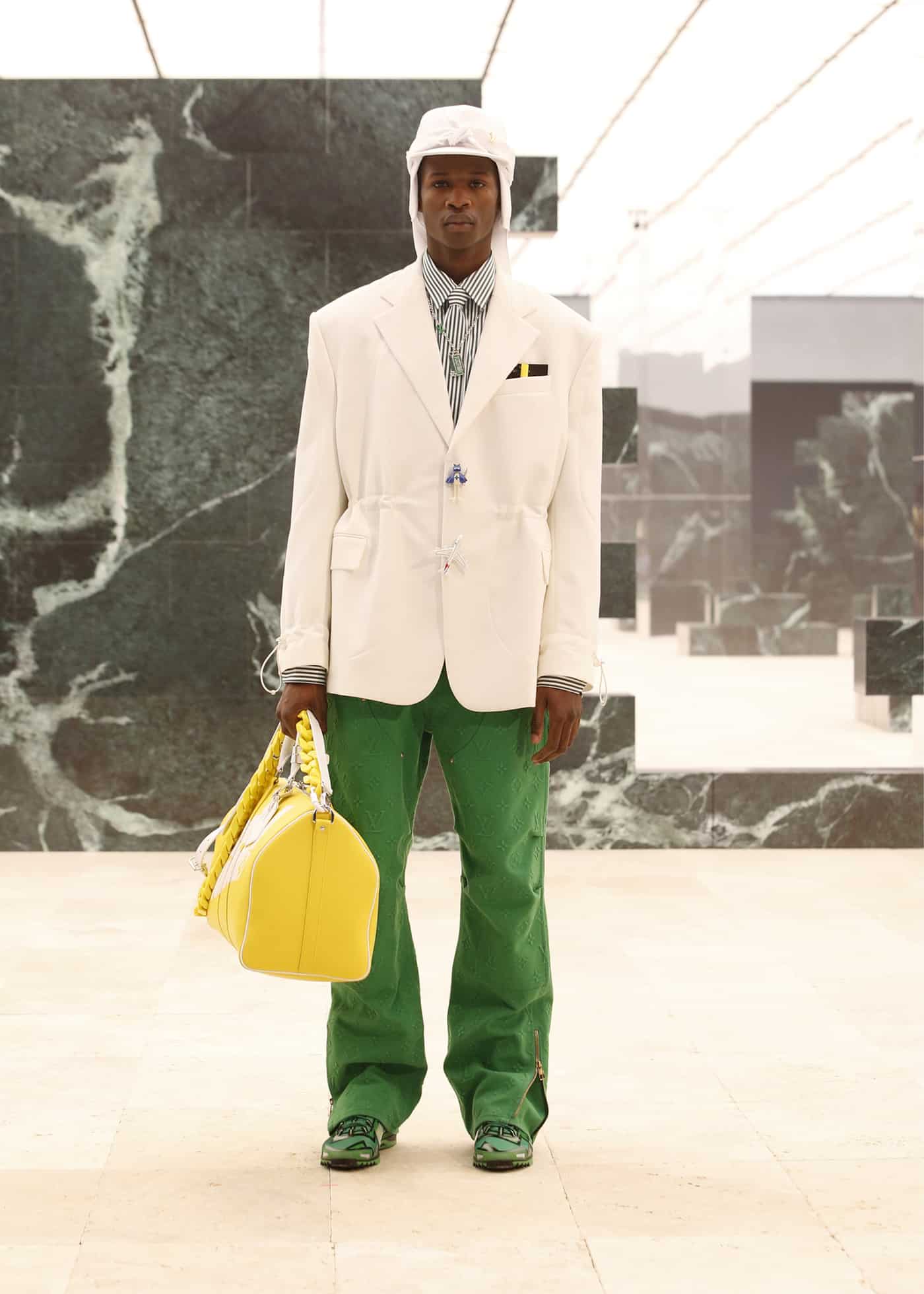 Man with black Moncler padded jacket, yellow trousers and blue Louis Vuitton  bag before Giorgio Armani fashion show, Milan Fashion Week street style on  January 15, 2018 in Milan. – Stock Editorial