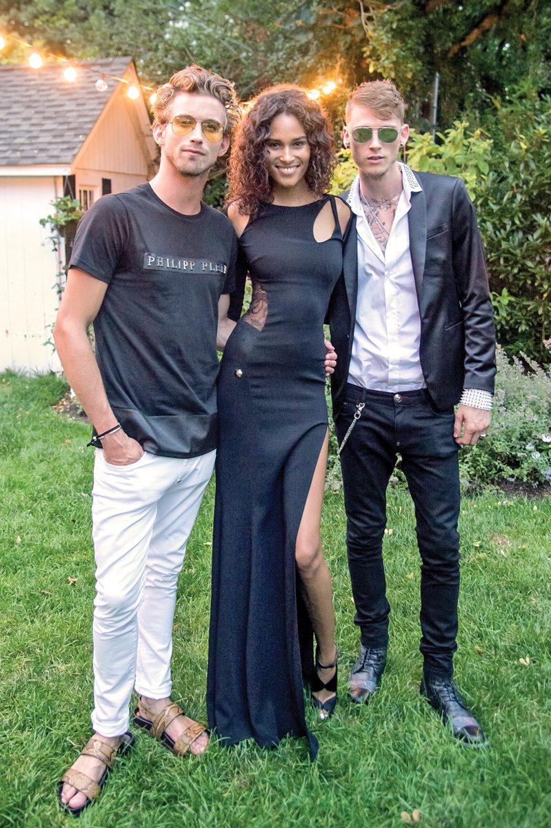 EAST HAMPTON, NY - JULY 16: Model RJ King, Model Cindy Bruna and Rapper Machine Gun Kelly attend Daily Front Row's Philipp Plein Dinner on July 16, 2016 at the Maidstone in East Hampton, New York. (Photo by Mark Sagliocco/Getty Images)